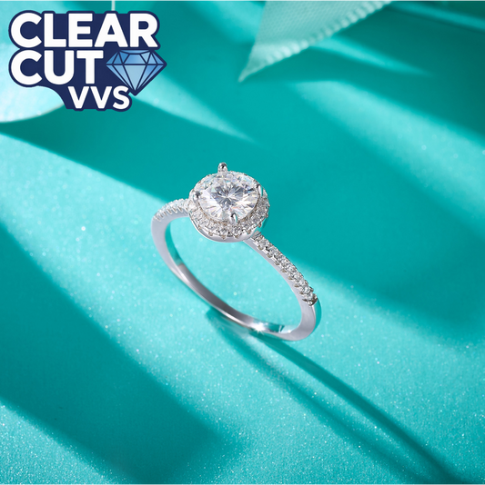 Diamond ring on a turquoise fabric background with 'Clear Cut VVS' branding.